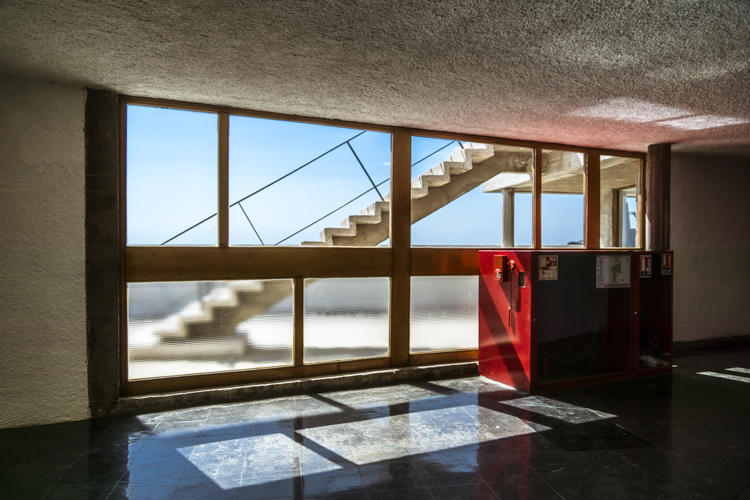 Au dernier étage de la Cité Radieuse du Corbusier à Marseille, une baie vitrée nous offre une vue sur le toit-terrasses en laissant passer la lumière.