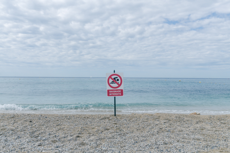Un panneau Baignade Interdite planté en plein milieu de la plage de la Grande Mer à Cassis.