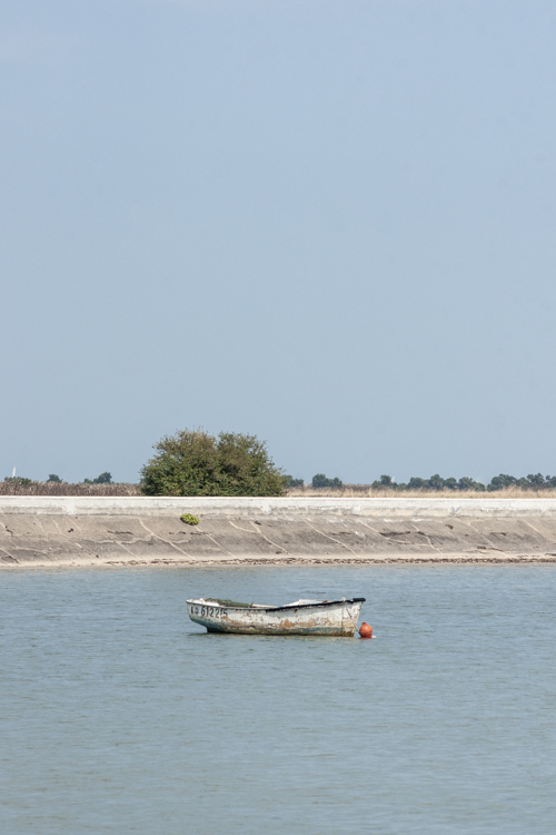 Une petite barque amarr�e � sa bou�e seul dans le port de Loix.