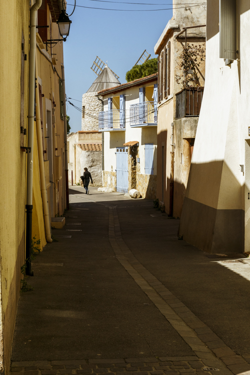 La silhouette d'une personne marchant dans la rue en direction d'un moulin � vent